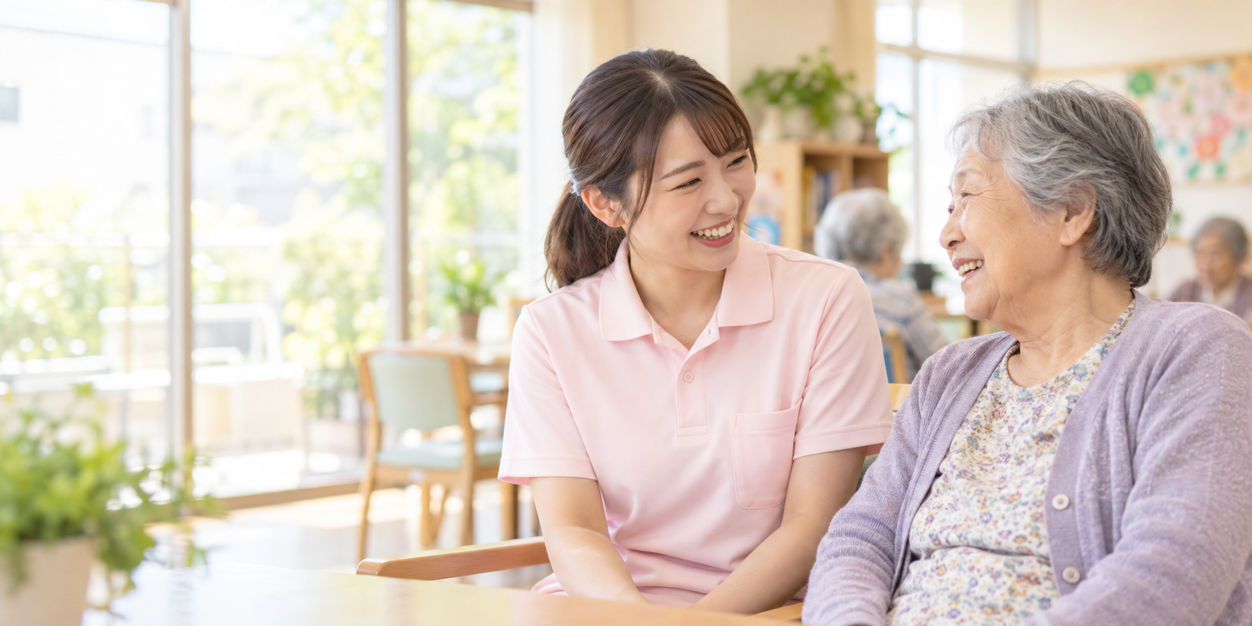 介護スタッフが利用者様と明るい室内で会話している様子